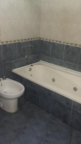 y baño con bañera blanca y aseo. en Bluingrin en Mar de las Pampas