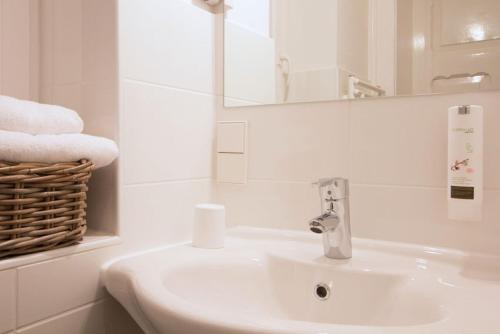 a bathroom with a sink and a mirror and towels at 1891 Hildesheim Boutique Hotel in Hildesheim