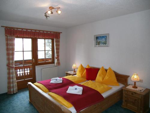 Schlafzimmer mit einem Bett mit gelben und roten Kissen in der Unterkunft Appartements Bacherhof in Schladming