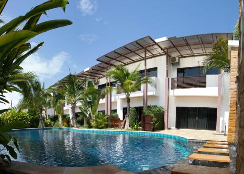 a swimming pool in front of a building at Oasis Garden & Pool Villa at VIP Resort in Ban Phe