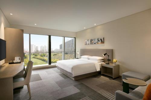 a bedroom with a bed and a desk and a room with a bed at Hyatt Place Shanghai Tianshan Plaza in Shanghai
