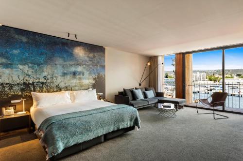 a bedroom with a bed and a large painting on the wall at MACq 01 Hotel in Hobart