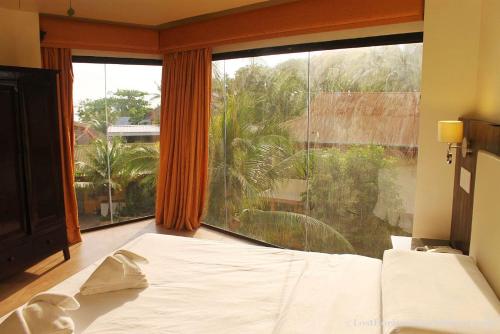 a bedroom with a bed and a large window at Lost Horizon Beach Dive Resort in Panglao Island