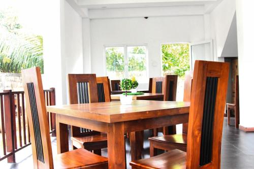 a dining room with a wooden table and chairs at Himawari Beach Villa in Matara