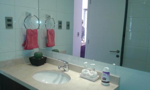 baño con lavabo y espejo grande en Departamento Atlántico 4030, en Viña del Mar