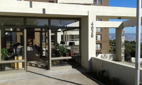 a building with glass doors with a view of a city at Departamento Atlántico 4030 in Viña del Mar