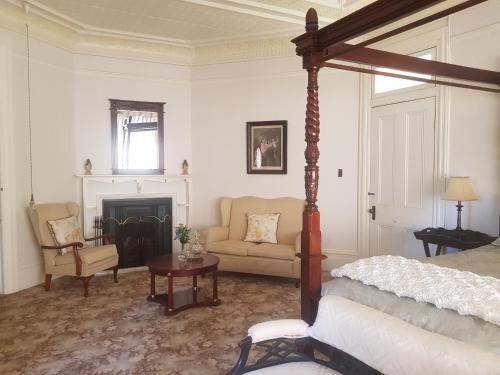 a bedroom with a bed and a chair and a fireplace at Blair Athol Homestead in Inverell