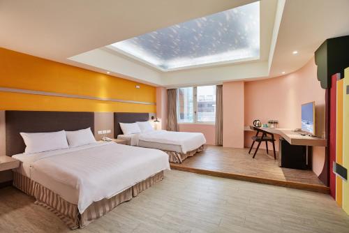 two beds in a hotel room with a skylight at Kenting City Gate Hotel in Hengchun
