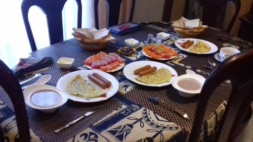 a table with plates of breakfast food on it at Villa A50 in Negombo