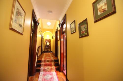 a hallway with yellow walls and a rug on the floor at Mountain Whispers Varenna Luxury in Leura