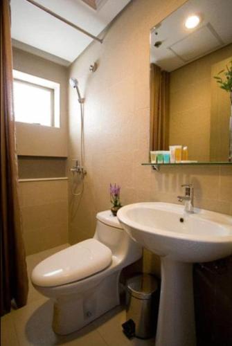 a bathroom with a white toilet and a sink at One Tagaytay Place Hotel Suites OFFICIAL ACCOUNT in Tagaytay