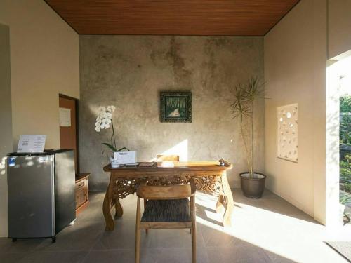 a dining room with a table and a refrigerator at Arnaya Homestay in Kuta