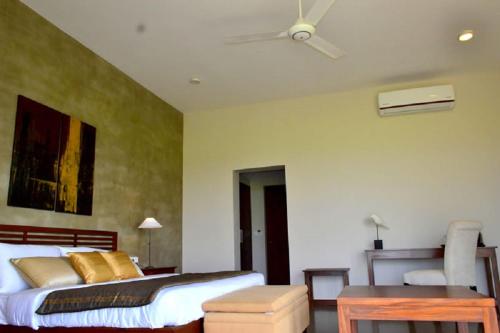 a bedroom with a bed and a ceiling fan at Kethaka Aga in Tissamaharama