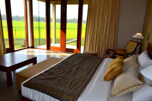 a bedroom with a large bed and a large window at Kethaka Aga in Tissamaharama