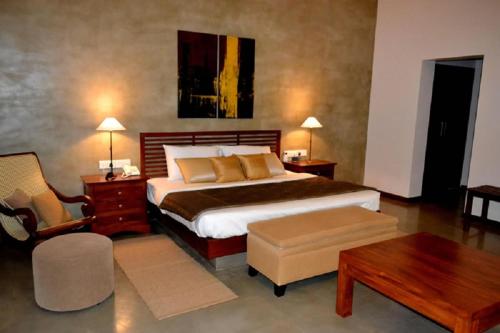 a bedroom with a large bed and a table at Kethaka Aga in Tissamaharama