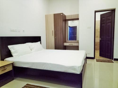 a bedroom with a large bed and a mirror at ComfortWings in Coimbatore