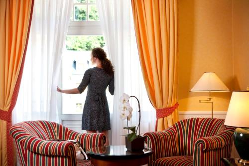 a woman is looking out of a window at Dvorak Spa & Wellness in Karlovy Vary