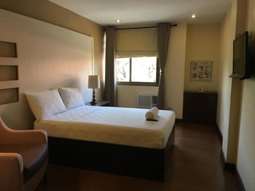 a hotel room with a bed and a window at Hotel Maiya in San Jose