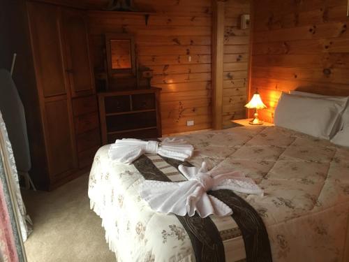 a bedroom with a bed in a log cabin at Boat Harbour Garden Cottages in Boat Harbour