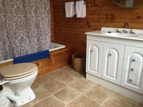 a bathroom with a toilet and a sink and a tub at Boat Harbour Garden Cottages in Boat Harbour