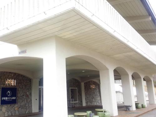 a large white building with columns and a staircase at Itoen Hotel Kusatsu in Kusatsu