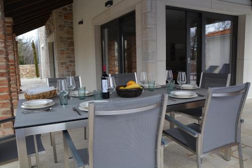 a table with two chairs and a table with wine glasses at Villa Kvarner in Krk