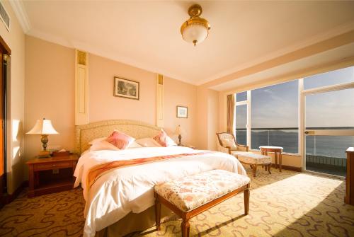 Кровать или кровати в номере Huiquan Dynasty Hotel Qingdao