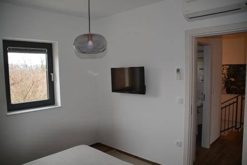 a room with a window and a tv on a wall at Villa Kvarner in Krk