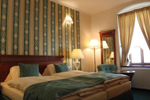 a hotel room with a large bed and a large window at Penzion U Karla IV. in Kadaň