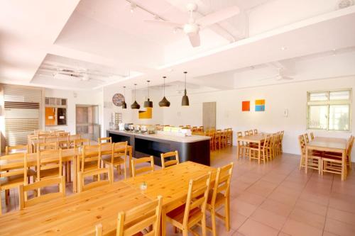 comedor grande con mesas y sillas de madera en Toong Hsiang Hotel, en Isla Verde