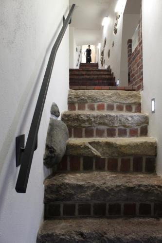 a set of stone stairs in a building with a person in the background at Penzion U Karla IV. in Kadaň