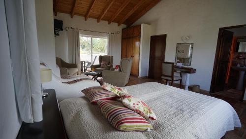 een slaapkamer met een bed met kussens erop bij Quinta do Paraiso in São Teotónio