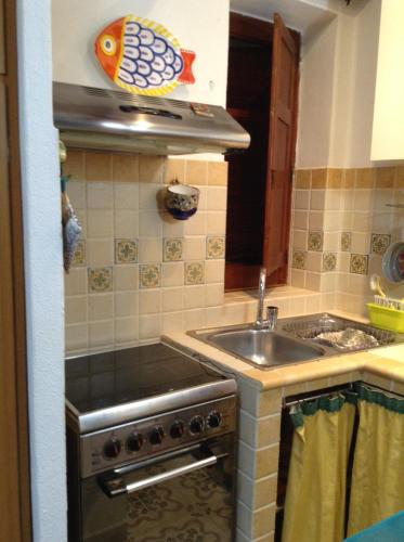 a kitchen with a sink and a stove at Residence Vulcano Cottage in Vulcano