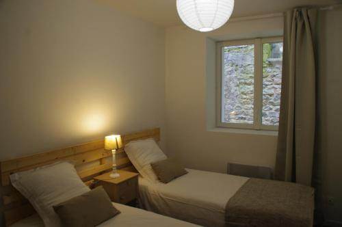 a bedroom with two beds and a window at La Cour Royale in Bayeux