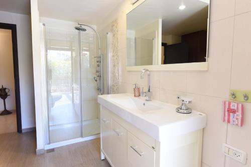 a white bathroom with a sink and a shower at Flintstone Guest House בית ההארחה בן 11 החדרים אינו וילה פרטית אתם מזמינים רק חדרים לא את כל הוילה in Eilat