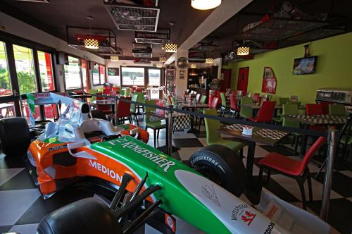 a racing car parked in a restaurant with tables and chairs at Enzo Hôtels Pont-à-Mousson BY Kyriad Direct in Pont-à-Mousson