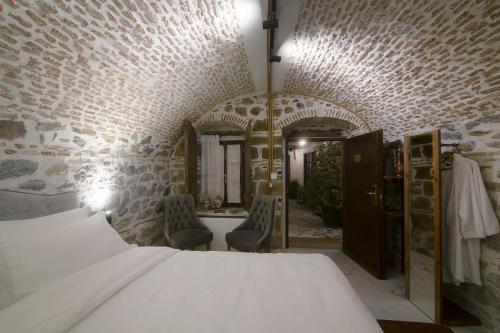 a bedroom with a bed and a bathroom with a mirror at HANI I PAZARIT Boutique Hotel in Korçë