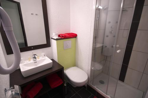 a bathroom with a sink and a toilet and a shower at Enzo Hôtels Pont-à-Mousson BY Kyriad Direct in Pont-à-Mousson