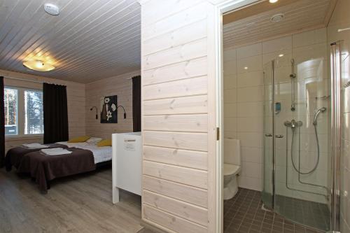 1 dormitorio con cama, ducha y baño en Tallusniemi Villas, en Oravi