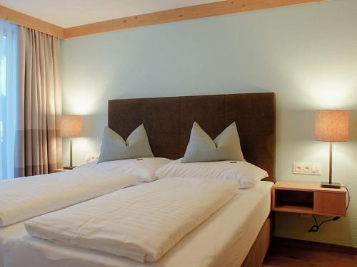 ein Schlafzimmer mit einem großen Bett mit weißer Bettwäsche und Kissen in der Unterkunft Gästehaus Prock in Mieders