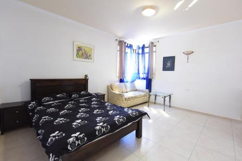 a bedroom with a bed and a chair in it at Flintstone Guest House בית ההארחה בן 11 החדרים אינו וילה פרטית אתם מזמינים רק חדרים לא את כל הוילה in Eilat
