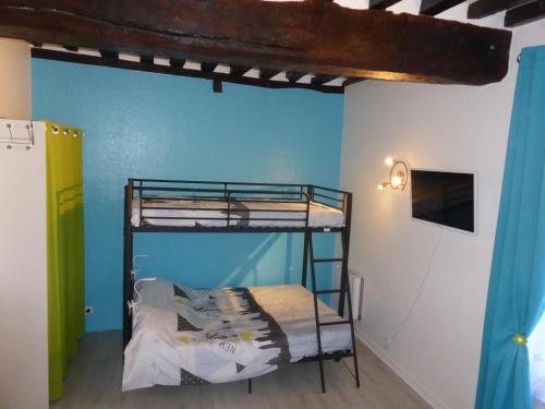 een slaapkamer met 2 stapelbedden en een blauwe muur bij Appartement Bayeux in Bayeux
