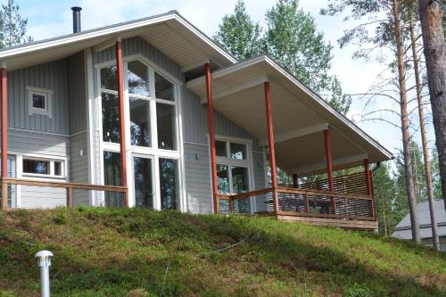 a house with a large window on a hill at Tallusniemi Villas in Oravi