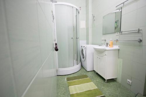 a white bathroom with a shower and a sink at Apartlux on Tverskaya Street in Moscow