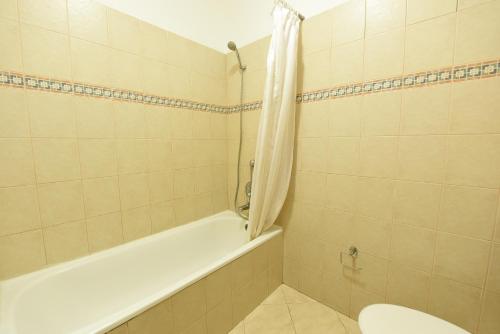 a bathroom with a tub and a toilet and a sink at Flintstone Guest House בית ההארחה בן 11 החדרים אינו וילה פרטית אתם מזמינים רק חדרים לא את כל הוילה in Eilat