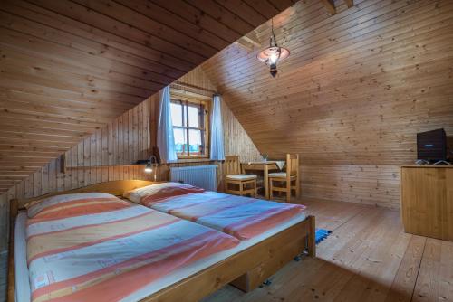 a bedroom with a bed in a wooden room at Chata Uhorčík in Terchová