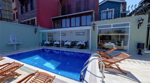 una casa con piscina y algunas sillas en HHK Hotel, en Estambul