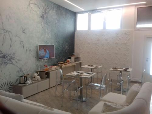 - un salon avec un canapé, des tables et des chaises dans l'établissement Centro Città Luxury B&B, à Foggia