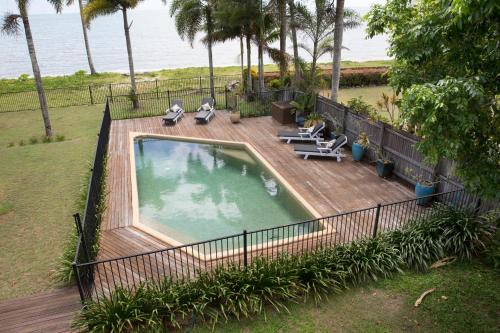 an overhead view of a swimming pool on a wooden deck at ABSOLUTE BEACHFRONT BLISS - NEWELL BEACH - 10 Metres to the Ocean in Newell Beach