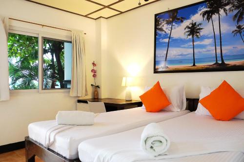 two beds in a room with two windows at Hippocampus Beach Resort in Malapascua Island